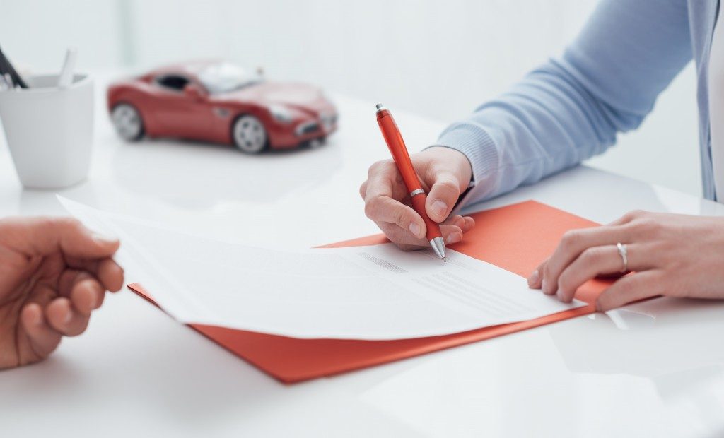 Woman signing a car insurance contract