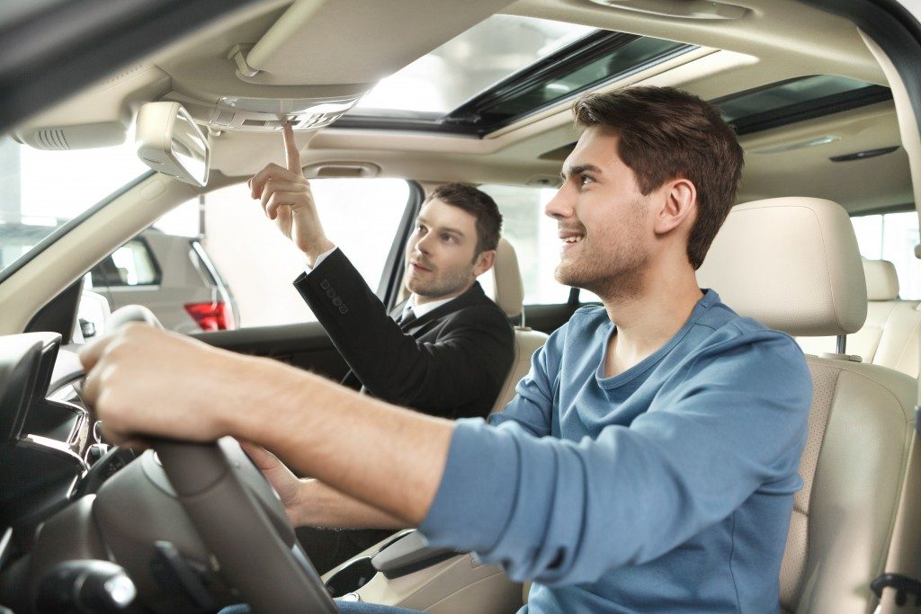 Salesman showing the car features to the buyer