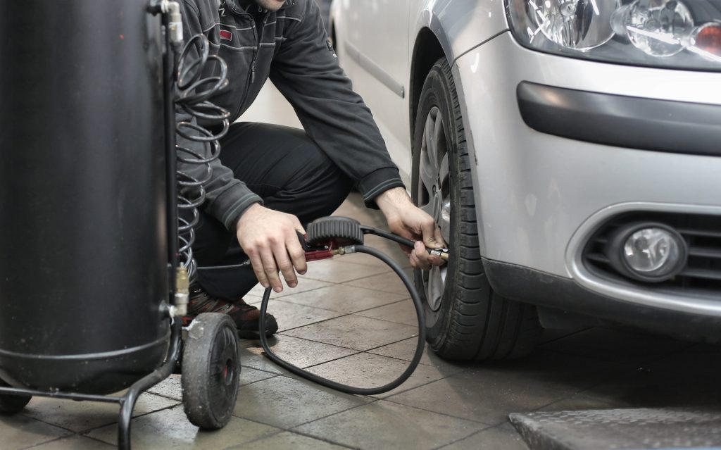 man putting air in tire