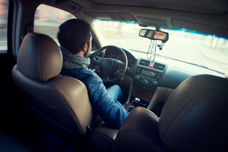 back view of a man wearing a hoodie while driving a car