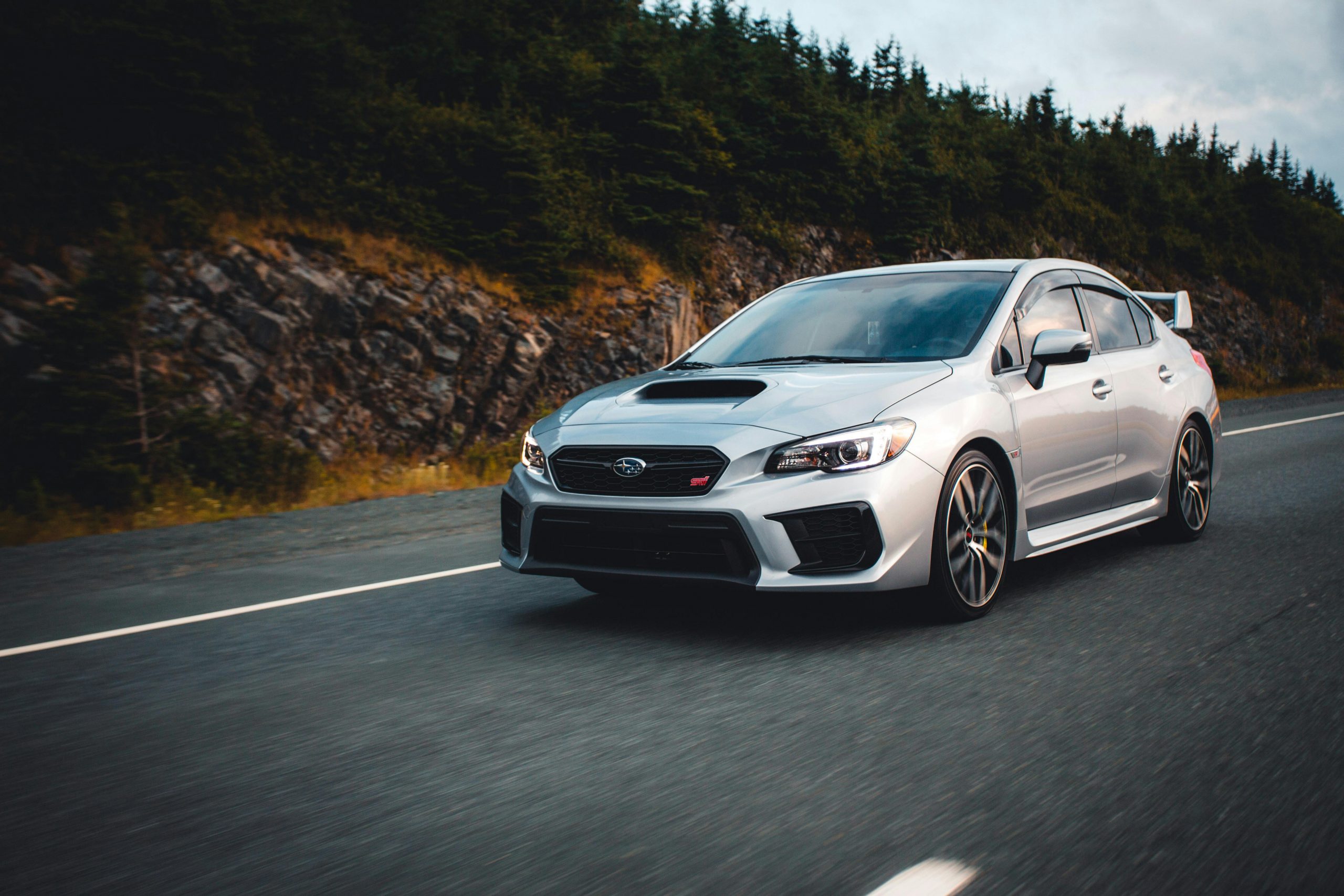 silver Subaru sedan speeding down the road