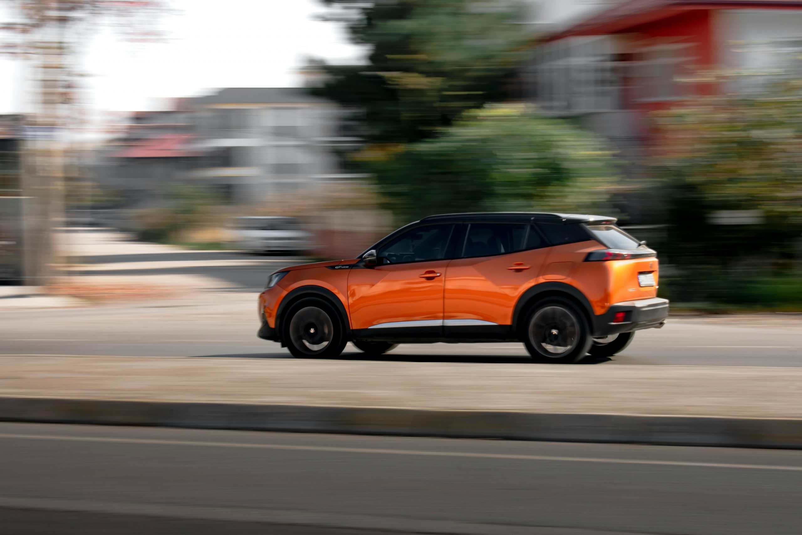 rust orange SUV speeding down the road